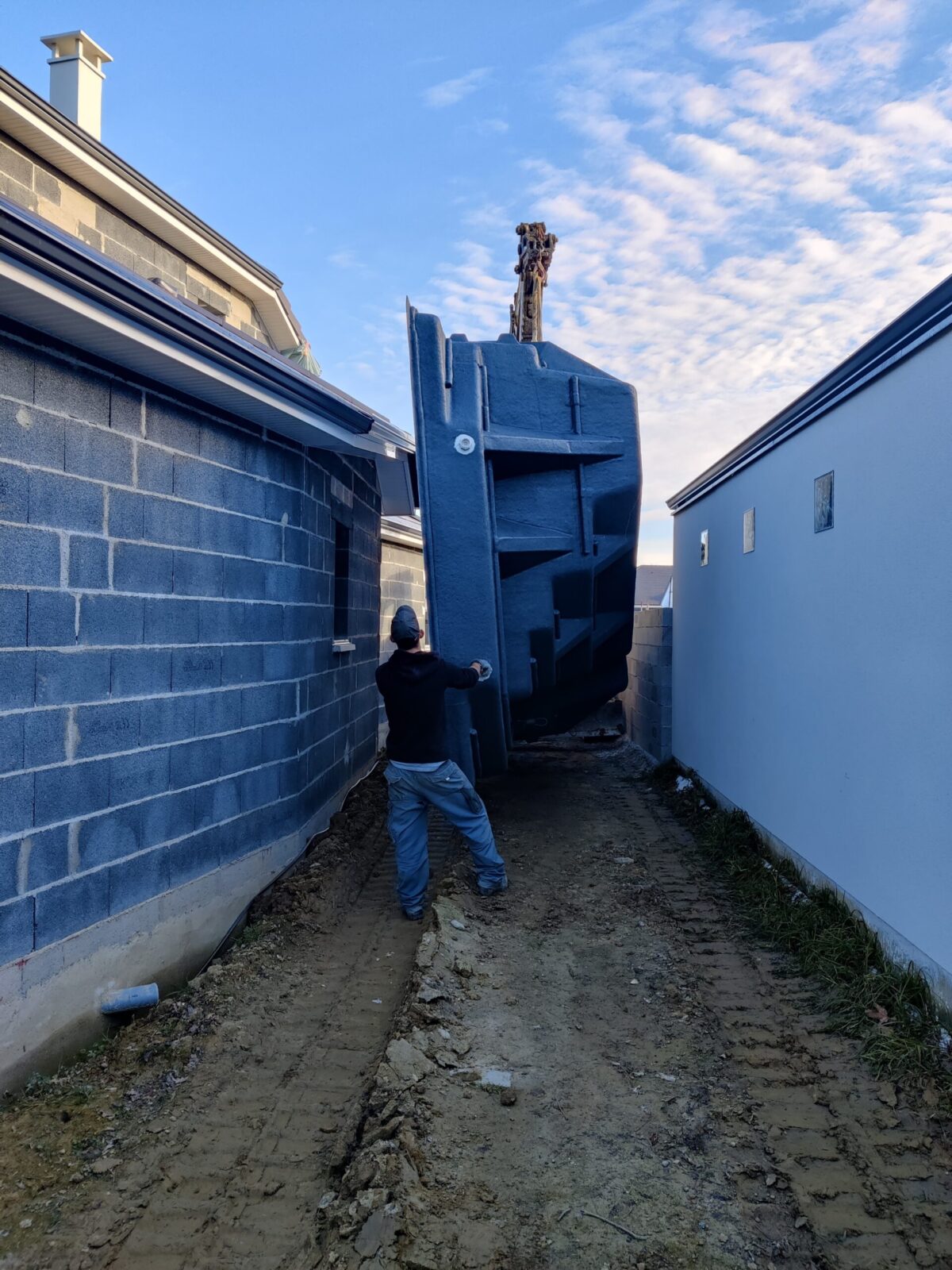 Livraison d'une piscine coque dans un accès étroit